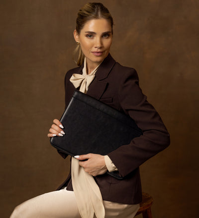 Woman holding the black Something Fresh leather portfolio close to her chest